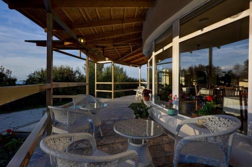 a patio with tables and chairs on a deck at Green Yard Hotel in Karakol