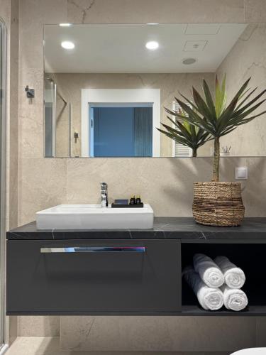 a bathroom with a sink and a mirror at Baltic Infinity Suite 529 - SPA & Pool Access in Międzyzdroje