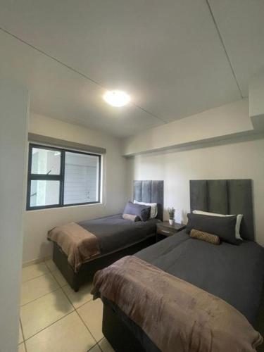 a bedroom with two beds and a window at Ballito Exotic Lifestyle in Ballito