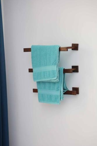 a towel rack with blue towels hanging on a wall at Mahaweli Haven in Nattarampota