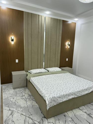 a bedroom with a large bed with marble floors at Asolat house in Urganch