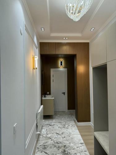 a hallway with a door and a chandelier at Asolat house in Urganch