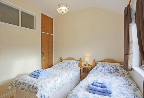 two beds in a bedroom with blue towels at 1 Bed in Beccles oc-hfs in Wangford