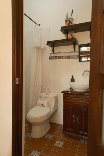 a bathroom with a toilet and a sink at Hotel Taa' Tiin in San Juan La Laguna