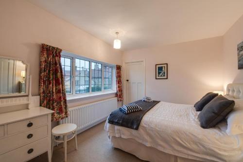 a bedroom with a bed and a dresser and a window at 2 Bed in Warkworth oc-nb319 in Warkworth