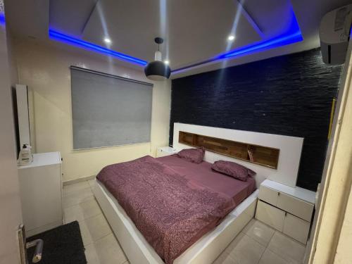 ein Schlafzimmer mit einem Bett mit einer lila Decke in der Unterkunft Mahmoud in Keur Massar