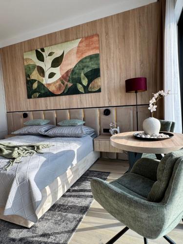 a bedroom with a bed and a table and chairs at Baltic Infinity Suite 529 - SPA & Pool Access in Międzyzdroje