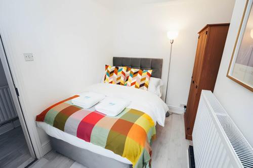 a bedroom with a bed with a rainbow blanket at 4 Bed House in Central Derby with Parking WiFi Smart TV in Derby