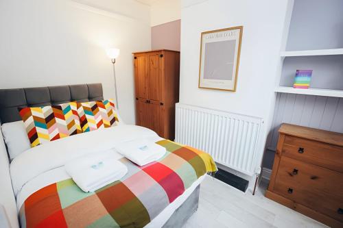 a bedroom with a bed with a colorful blanket at 4 Bed House in Central Derby with Parking WiFi Smart TV in Derby