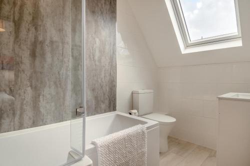 a bathroom with a tub and a toilet and a window at 2 Bed in Cromer oc-f28893 in Cromer