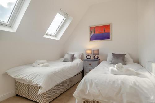 two twin beds in a room with two windows at 2 Bed in Cromer oc-f28893 in Cromer