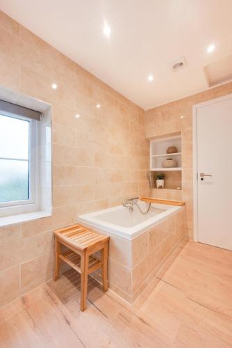 a bathroom with a tub and a table and a window at 6 Bed in Bacton oc-2316 in Bacton