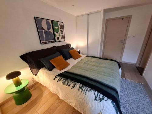 a bedroom with a large bed with a green lamp at L annexe in Saint-Jean-d'Aulps