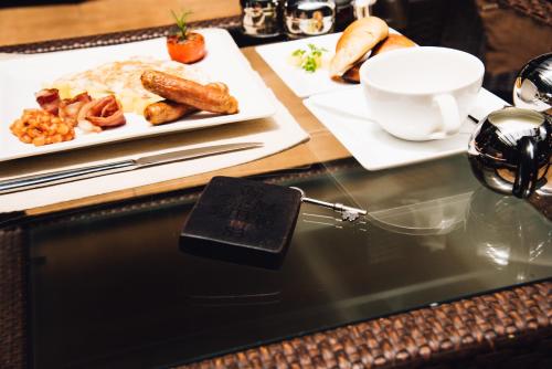 een tafel met daarop een bord met eten en een onderbord bij GemSuites Serviced Apartments State House in Nairobi