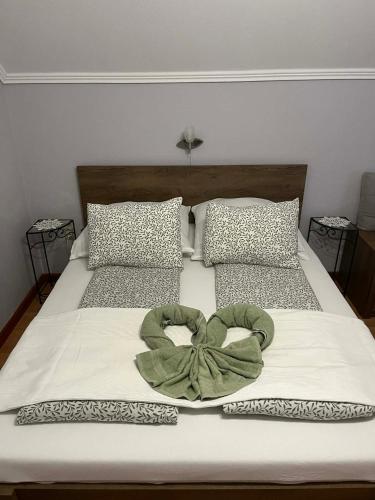 a bed with a green bow on it at Pusztavár-Lak in Erdőhorváti