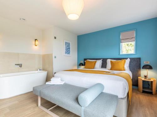 a bedroom with a large bed and a blue wall at 2 Bed in Saltash oc-87701 in St. Mellion