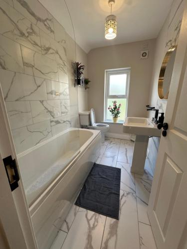 a bathroom with a tub and a sink and a toilet at Belles Haven in Belfast