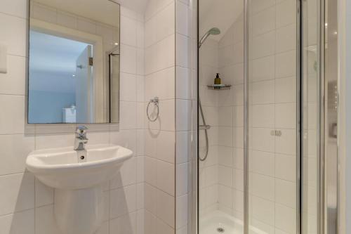 a white bathroom with a sink and a shower at 3 Bed in Knodishall oc-ebco in Aldringham