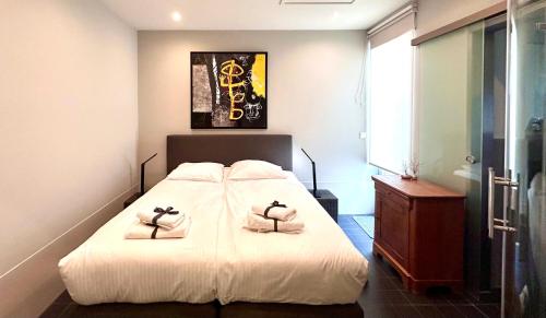 a bedroom with a bed with two towels on it at V06 Seasidevilla Vlissingen in Vlissingen