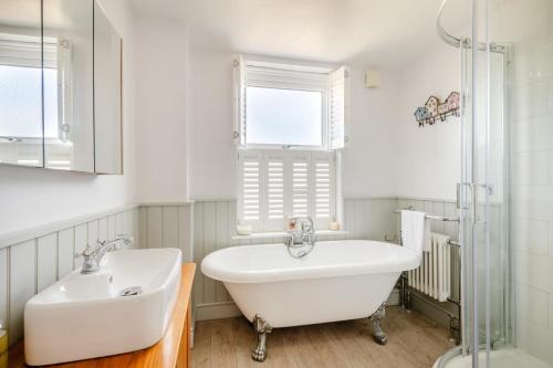 a bathroom with a tub and a sink and a window at 3 Bed in Wrentham oc-15mill in Wrentham