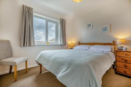 a bedroom with a bed and a chair and a window at 3 Bed in Padstow oc-p00131 in Saint Merryn