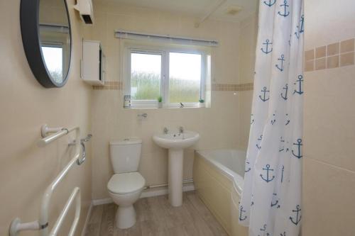 a bathroom with a toilet and a sink and a shower curtain at 3 Bed in Padstow oc-p00131 in Saint Merryn