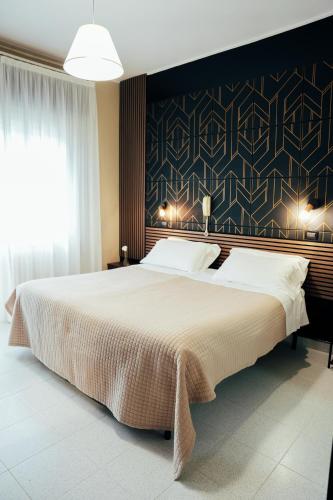 a bedroom with a large bed and a black wall at Hotel Marconi in Fiuggi