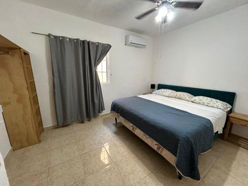 a bedroom with a bed and a ceiling fan at Xcalacoco Beach in Playa del Carmen