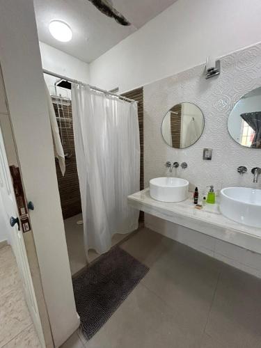 a bathroom with a sink and a mirror and a shower at Xcalacoco Beach in Playa del Carmen