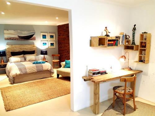1 dormitorio con 1 cama y escritorio en una habitación en Cottage Guesthouse en Pretoria