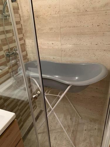 a shower with a white tub in a bathroom at Pusztavár-Lak in Erdőhorváti
