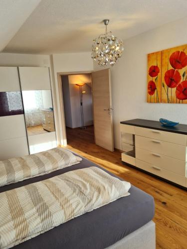 a bedroom with two beds and a dresser with a mirror at Ferienwohnung Sonnenschein mit Sauna und Billiard in Wachstein