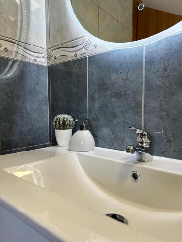 a bathroom sink with a mirror and a white sink at Maria apartment in Ponta do Sol