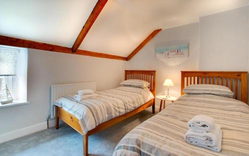 two twin beds in a room with a window at 3 Bed in Craster oc-79891 in Craster