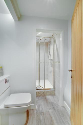 a white bathroom with a shower and a toilet at 2 Bed in Kettlewell oc-ds985 in Kettlewell