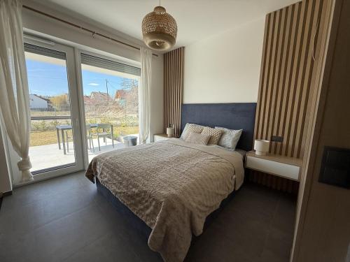 a bedroom with a bed and a large window at The Balaton Nest! in Alsóörs