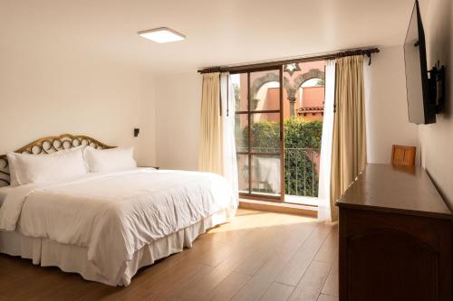 a bedroom with a bed and a large window at Pasaje Las Rosas in Cuernavaca