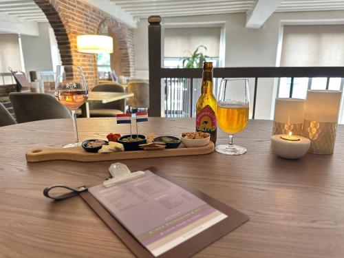 a table with a tray of food and glasses of wine at Grand Canal Boutique Hotel Delft in Delft