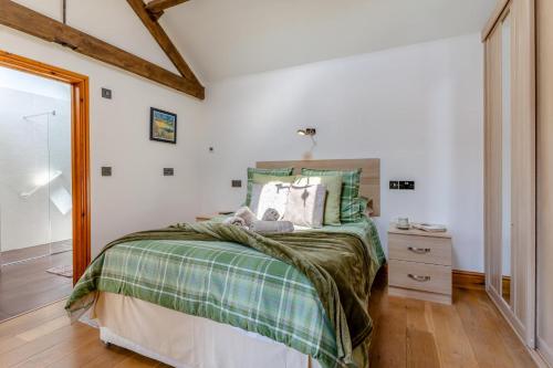 a bedroom with a bed with a green blanket at 1 Bed in Wonastow oc-l29426 in Wonastow