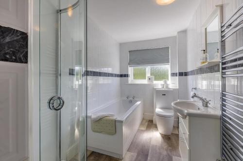 a bathroom with a tub and a toilet and a sink at 5 Bed in Clows Top oc-m32976 in Bayton