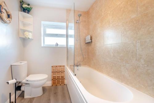 a bathroom with a toilet and a tub and a sink at 1 Bed in Bridlington oc-t30002 in Bridlington