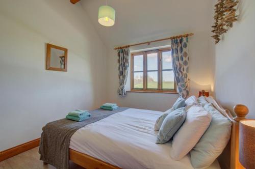 a bedroom with a bed with white sheets and a window at 2 Bed in Roughton oc-1626 in Roughton