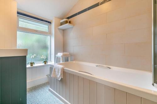 a bathroom with a large tub and a window at 3 Bed in Porthleven oc-7bayvi in Porthleven