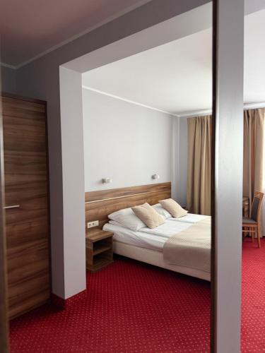 a bedroom with a bed and a large mirror at Hotel Luzino in Luzino