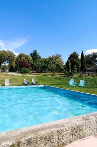 a swimming pool with two lawn chairs and two chairs at Casa da Vinha in Castelo Novo