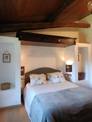 a bedroom with a large bed with a wooden ceiling at Casa da Vinha in Castelo Novo