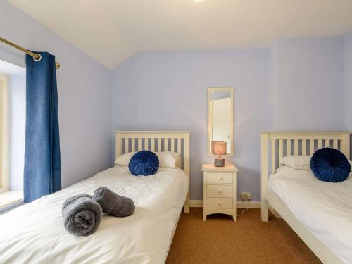 two twin beds in a room with a mirror at 4 Bed in Bakewell oc-pk911 in Bakewell