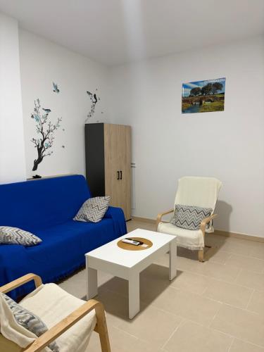 a living room with a blue couch and a table at Casa 22 in Plasencia