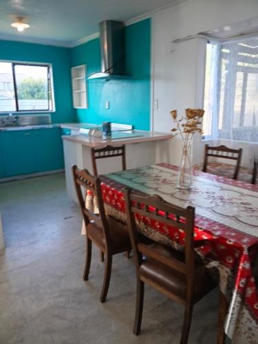 a dining room with a table and chairs and a kitchen at Budget accommodations 2 in Papamoa