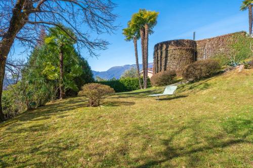 a park bench sitting on a grassy hill with palm trees at Casa Sophie in Luino